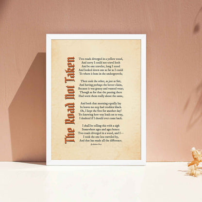 A vintage-style poem print featuring Robert Frost’s iconic poem, The Road Not Taken printed on an aged, old-paper background, in white frame.