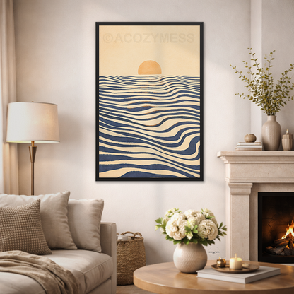 A framed vertical art print featuring a minimalist navy blue sea waves with a yellow sun, displayed on a wall in a cozy living room setting next to a fireplace and sofa.