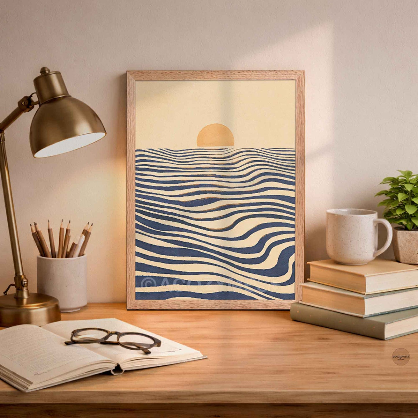 An oakwood color framed art print featuring bluewater waves with a small yellow sun, displayed on a wooden desk in a styled room setting.