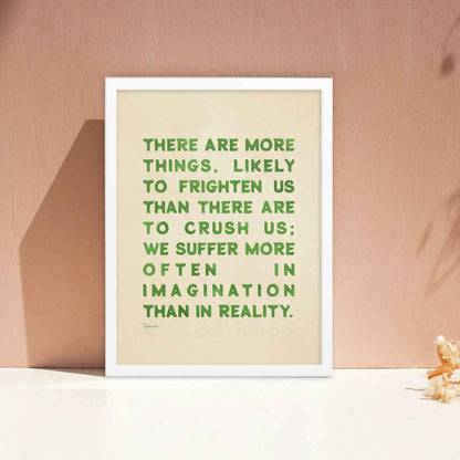 Seneca Poster with quote on fear, green on beige, displayed in white frame