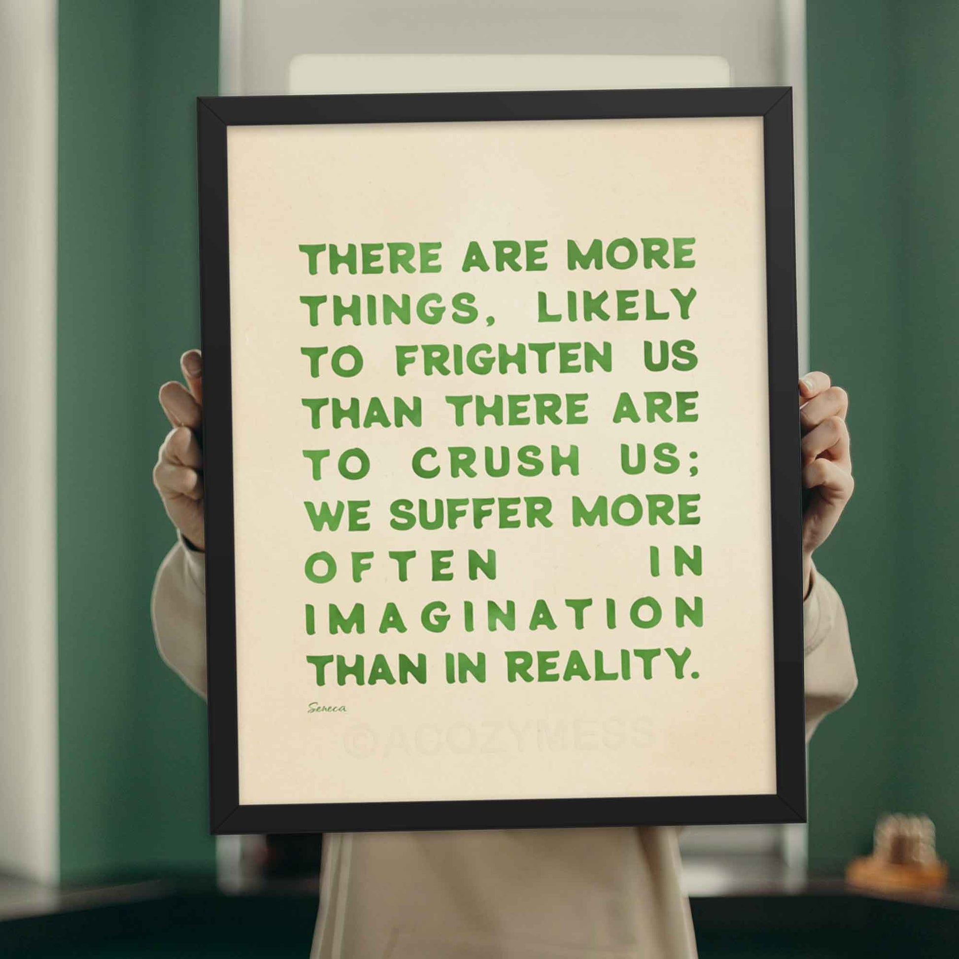 Seneca quote on fear print, green on beige, displayed in black frame.