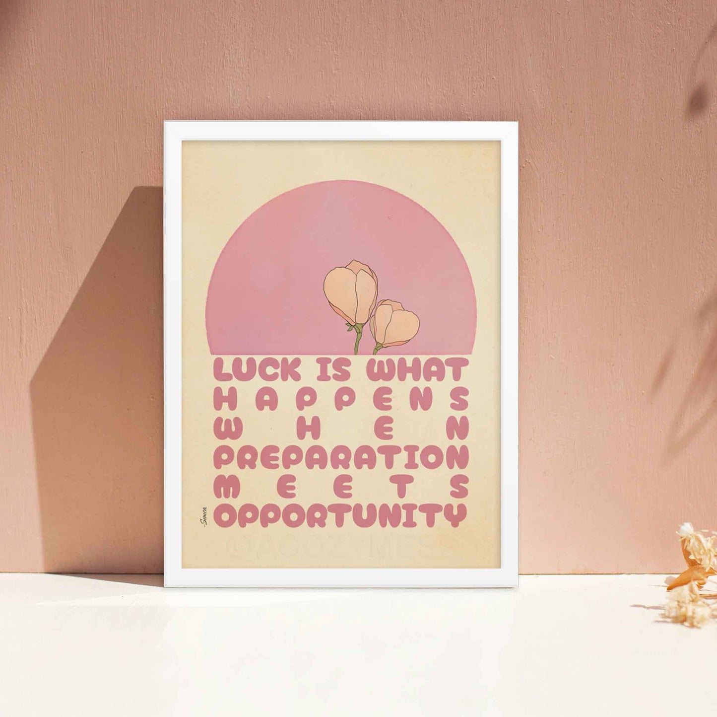 Seneca poster with the quote, Luck is what happens when preparation meets opportunity, in pink and beige with a delicate floral design, displayed in a white frame. 