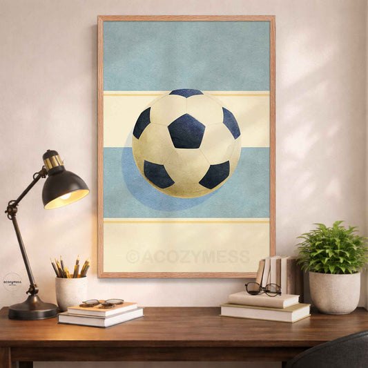 Oakwood Framed poster of a soccer ball on a wall above a desk with a lamp and books.