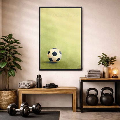 Framed artwork of a soccer ball on green background hanging on a wall in a home gym setting.