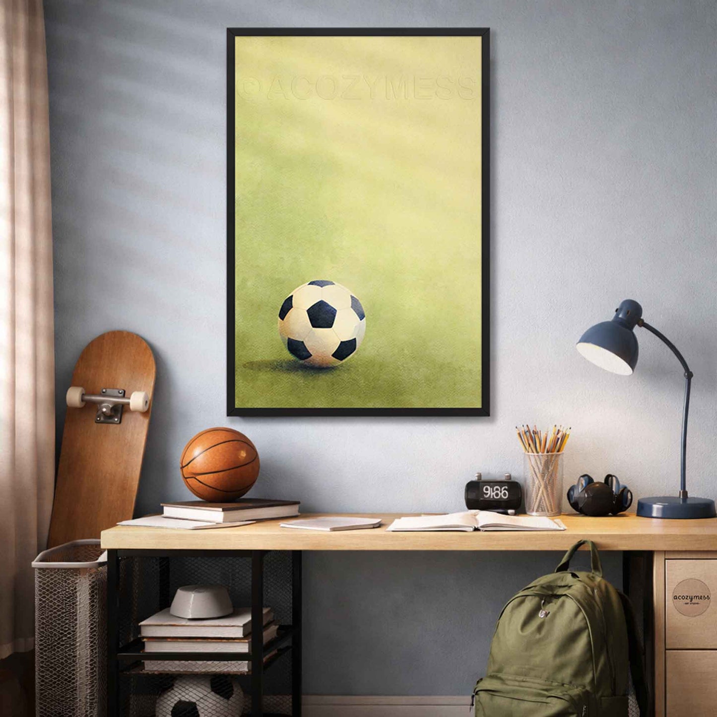 Room interior with a black framed poster of a soccer ball, desk with sports balls, and lamp.