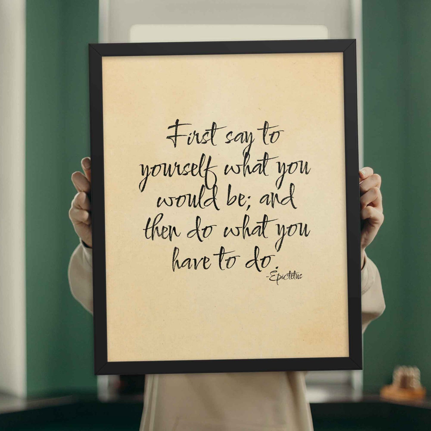 First say to yourself what you would be and then do what you have to do, a quote By Epictetus, black on beige, displayed in black frame poster.