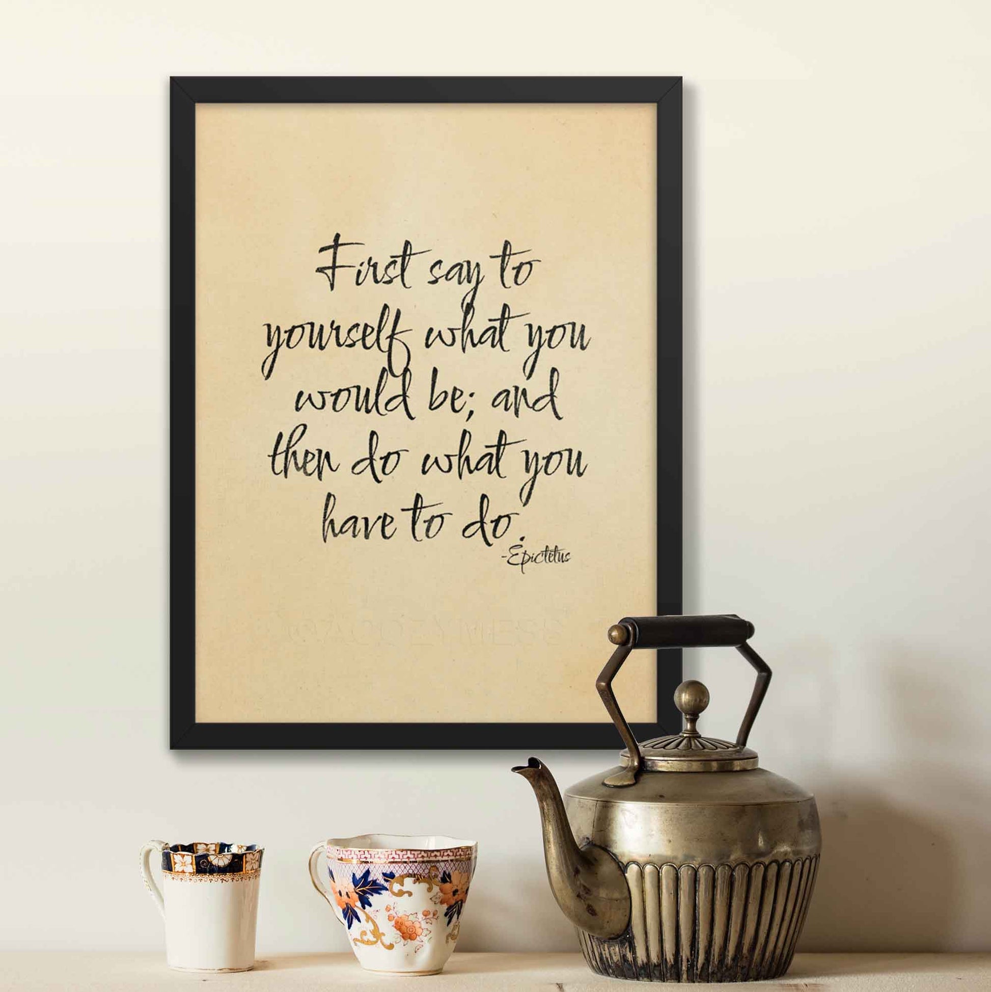 First say to yourself what you would be and then do what you have to do, a quote By Epictetus, black on beige, displayed in black frame poster.