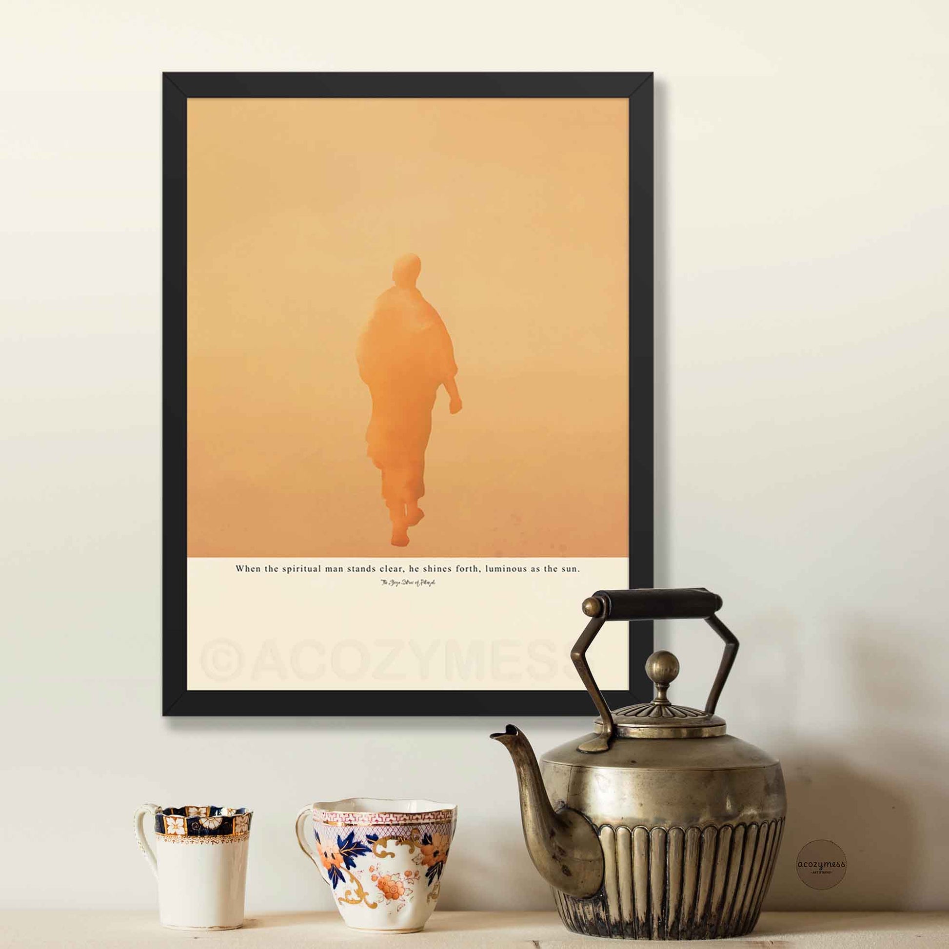 Framed artwork with a silhouette of a person on an orange background, in black frame on beige background.
