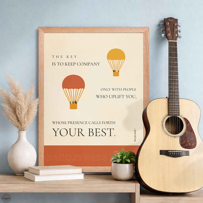 Framed motivational poster with hot air balloons and a guitar on a table.
