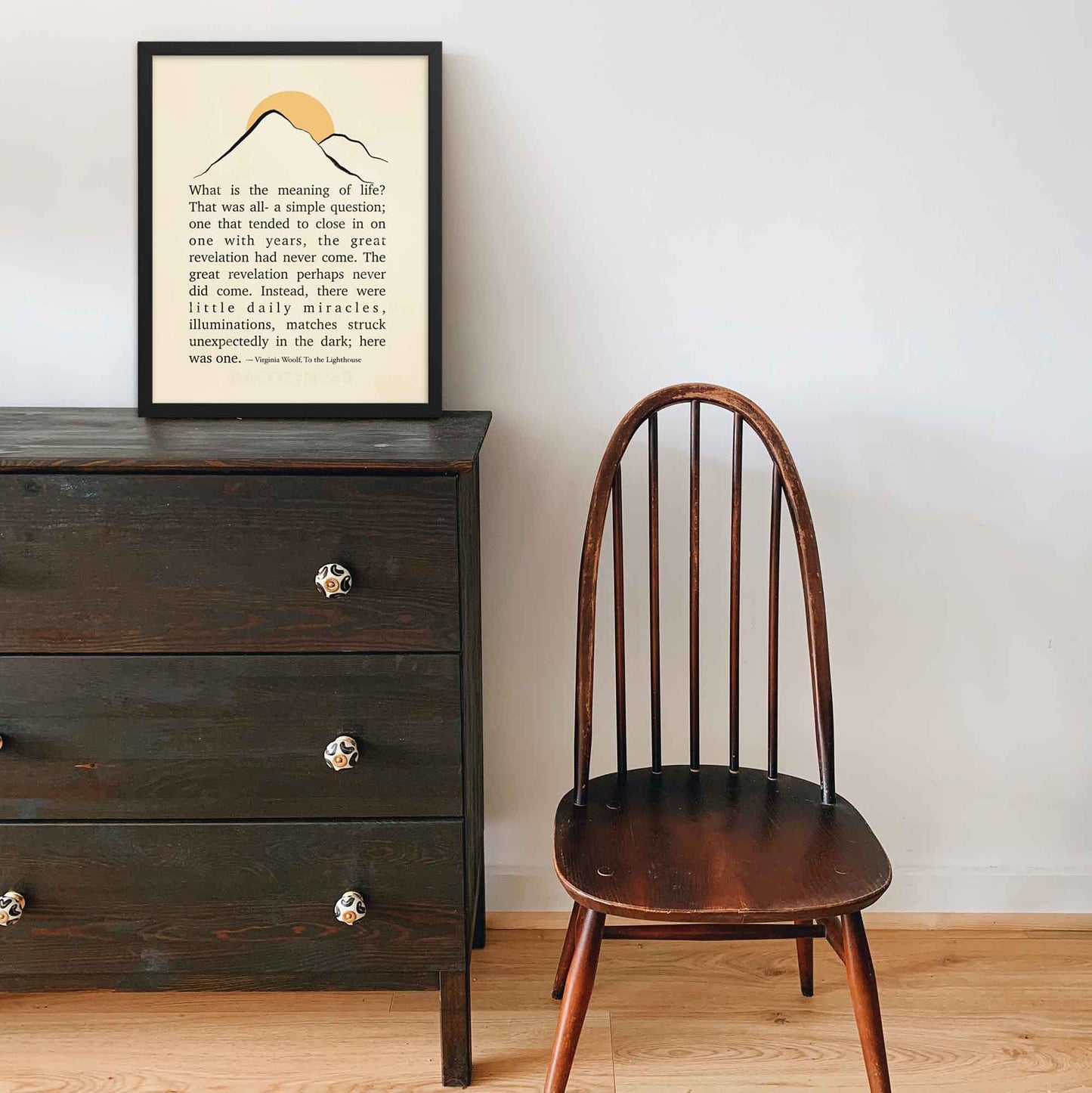 Virginia Woolf print from To the Lighthouse, featuring minimalist mountain and sun illustration, displayed in a black frame.