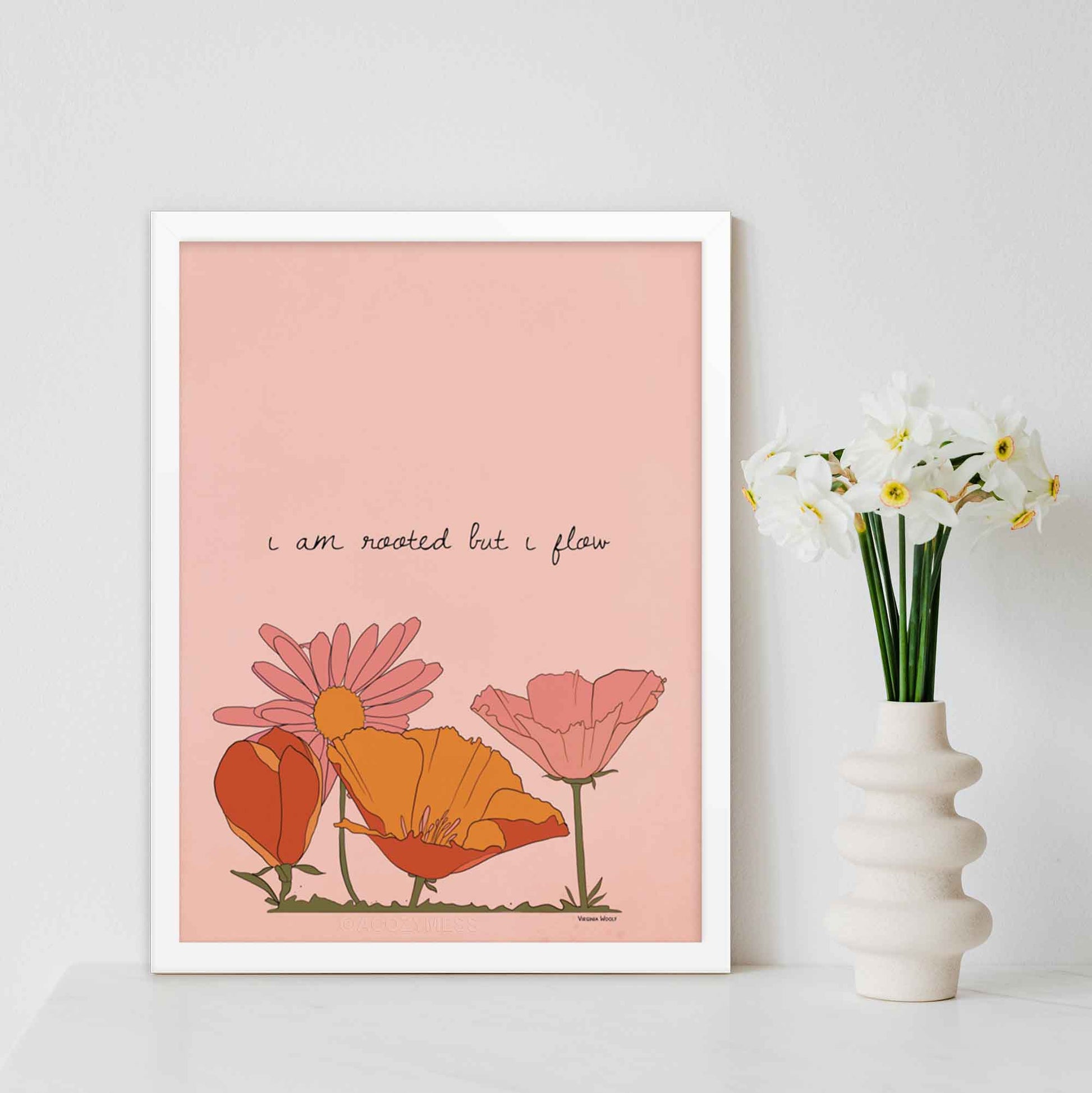 "Art print featuring Virginia Woolf's quote 'I am rooted, but I flow,' with a vibrant floral illustration in pink, orange, and yellow hues," in white frame.