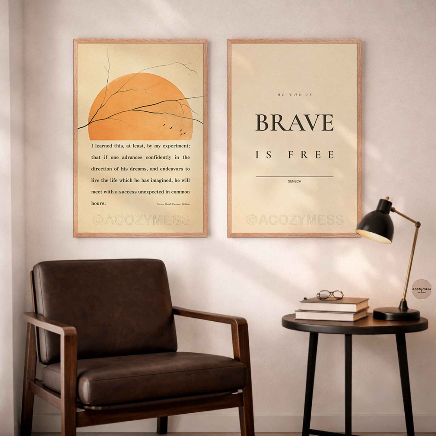 Two framed motivational posters on a wall above a brown armchair with a small table and lamp.