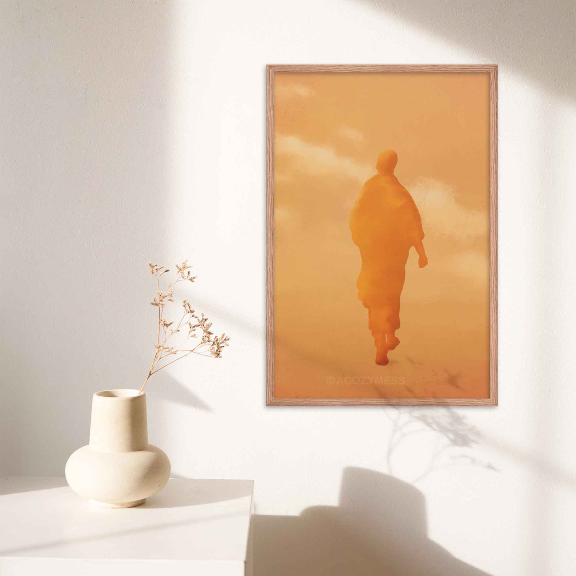 Art print of a walking monk in warm orange and yellow hues, capturing serenity and spiritual presence, in oakwood frame.