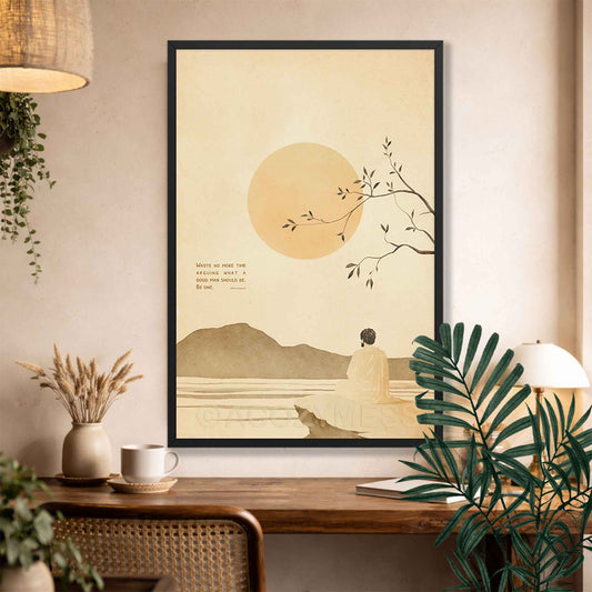 Black Framed Stoic art  of a person by a lake with a large sun, placed on a wall above a wooden desk.