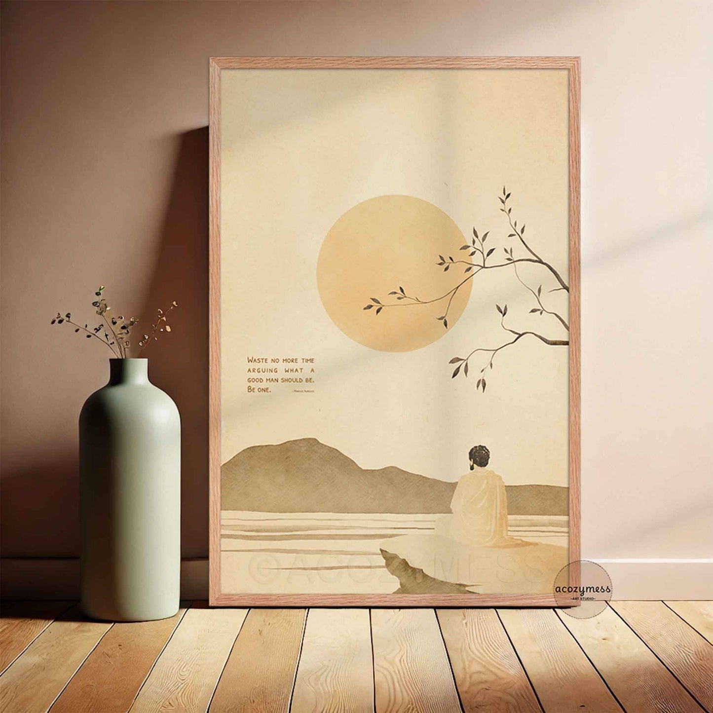 oakwood Framed stoic quote artwork of a person by a lake with a mountain and sun in the background, placed on a wooden floor.