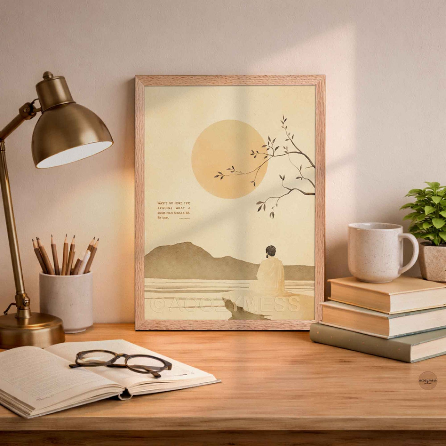 Oakwood Framed Marcus Aurelius print with his quote and an illustration  of a person by a tree with a sunset, placed on a desk .