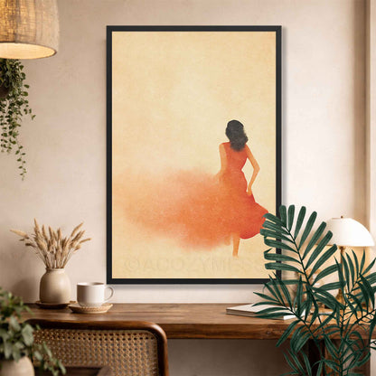 Black Framed artwork of a woman in an orange dress on a wall above a wooden desk with plants.