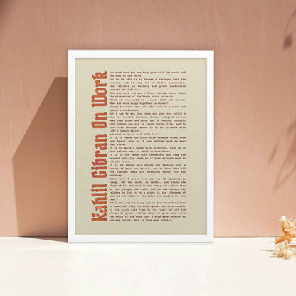 Work motivational print by Kahlil Gibran in white frame.