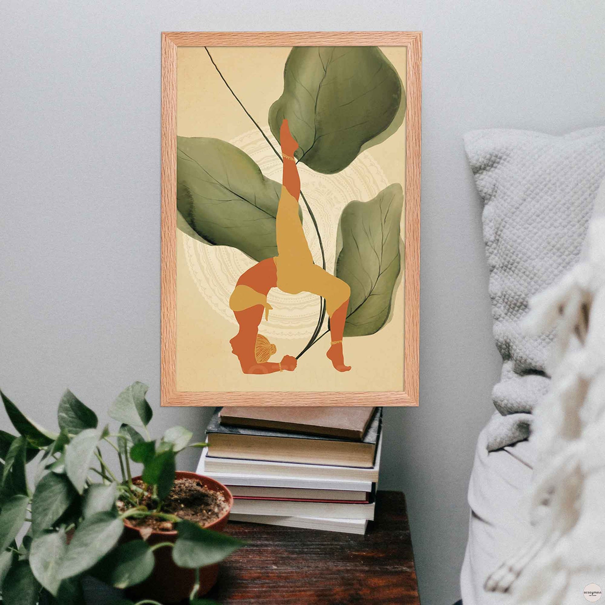 A oakwood-framed poster featuring an illustration of a woman in a yoga pose, set against a backdrop of large leafy plants and mandala art in earthy tones for calming corner decor.