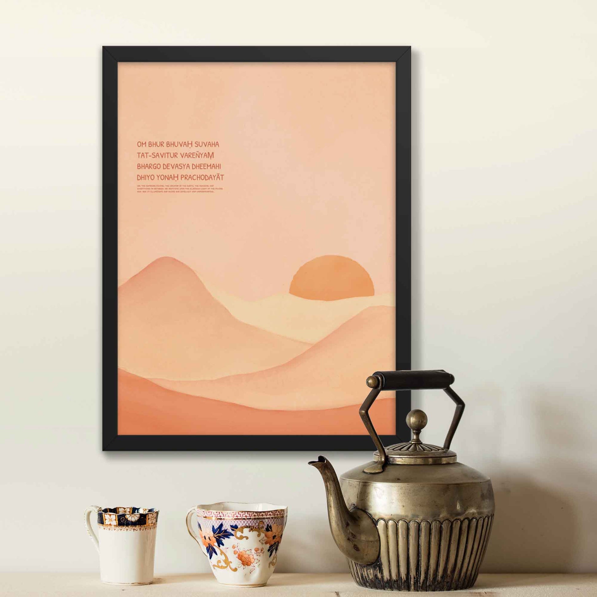 Gayatri Mantra poster featuring calming landscape art in a light color palette, displayed in a black frame, spiritual decor