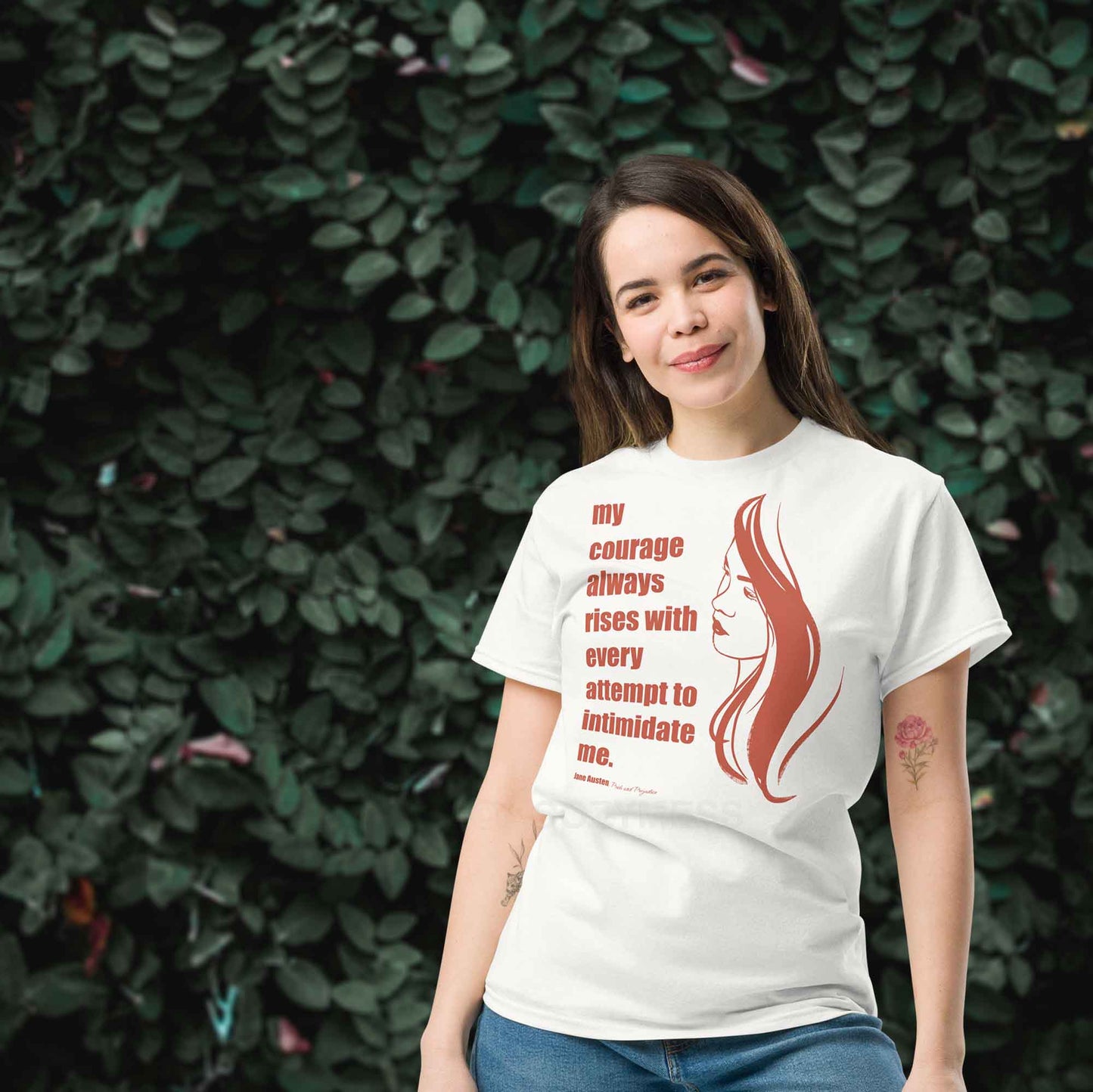 A woman wearing white T-shirt featuring a  illustration of a woman portrait alongside a Jane Austen quote: "Courage always rises with every attempt to intimidate me.