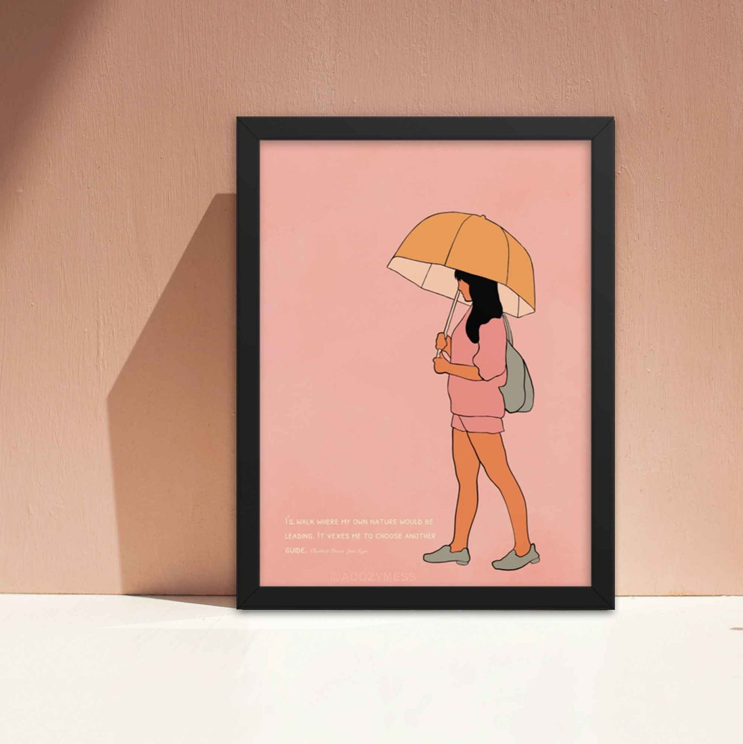 Pink art print with a quote from Charlotte Brontë's Jane Eyre and an illustration of a girl walking with an umbrella, emphasizing independence and self-guidance, in black frame