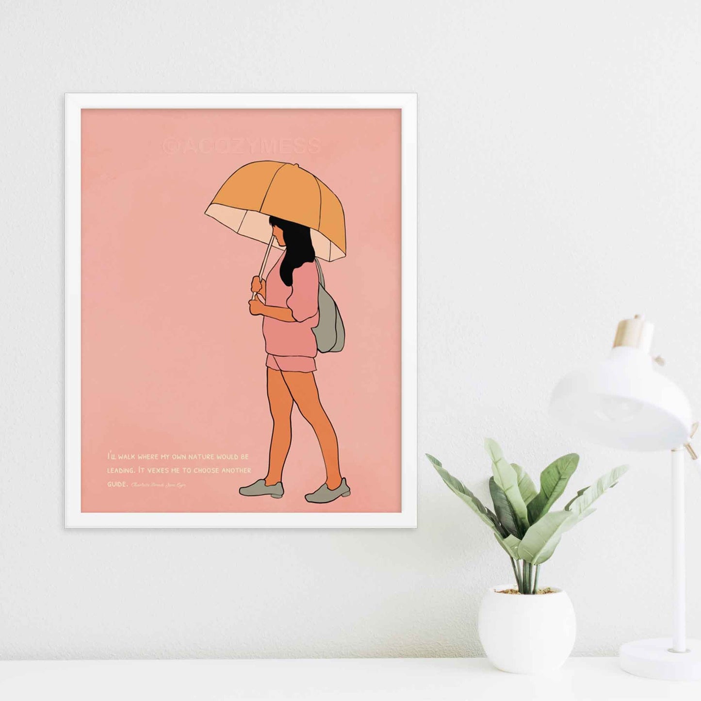 Pink art print with a quote from Charlotte Brontë's Jane Eyre and an illustration of a girl walking with an umbrella, emphasizing independence and self-guidance, white frame.