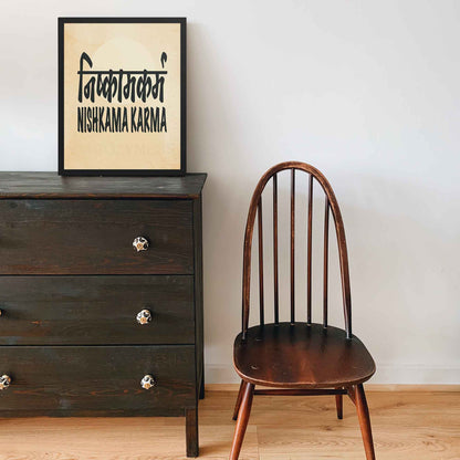 A black-framed typography poster featuring the concept of Nishkama Karma (निष्काम कर्म) in both Hindi and English on an aged, old-paper background for mindful spaces.