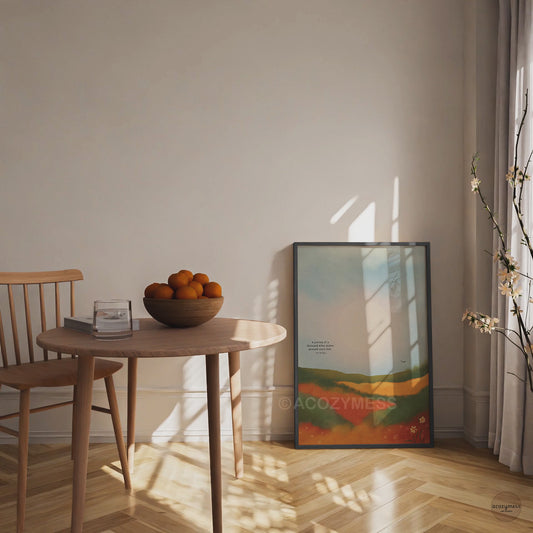 Black framed Tao Te Ching quote poster with the text “A journey of a thousand miles begins beneath one’s feet,” set over a colorful landscape.