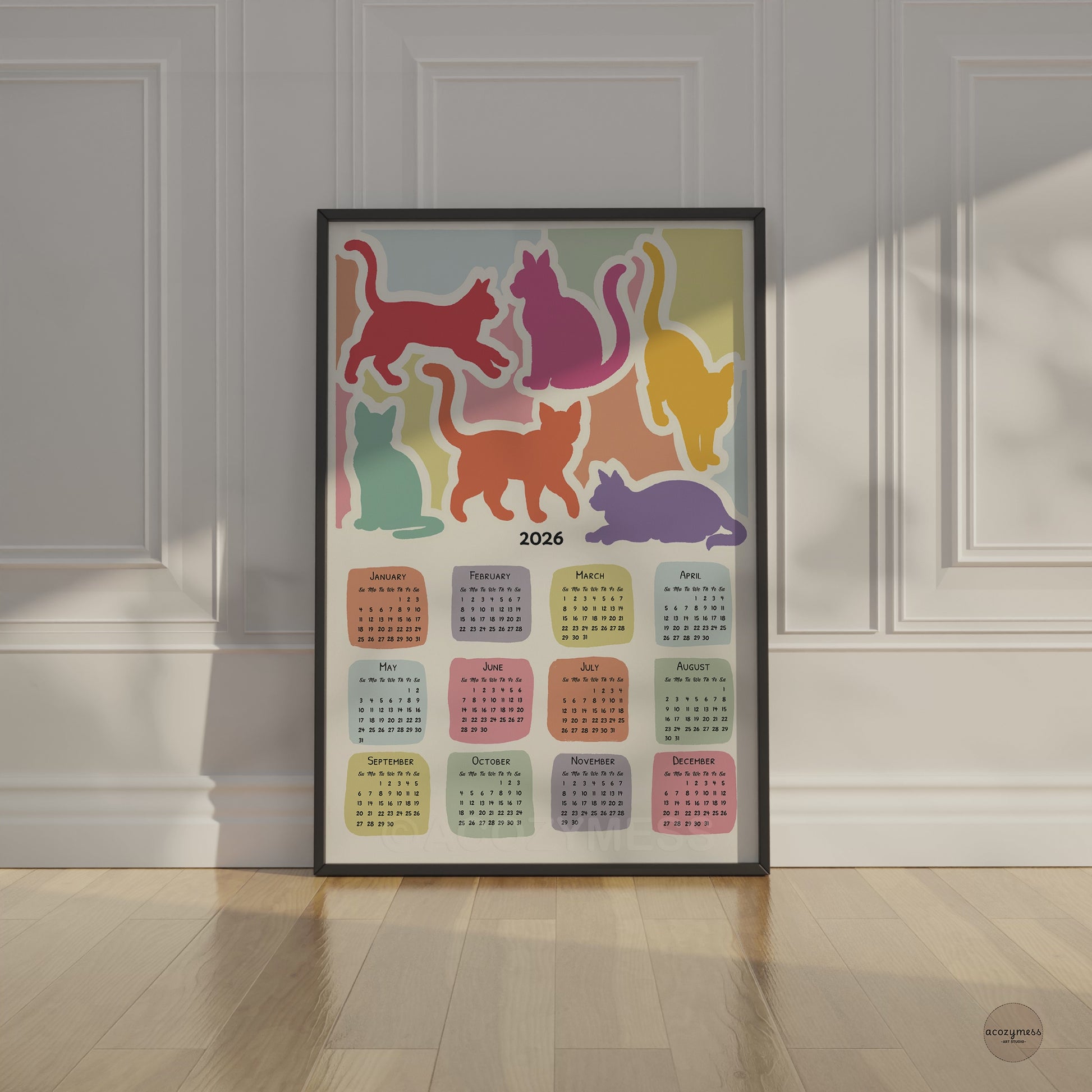 2026 yearly calendar with cute cats art displayed in black frame