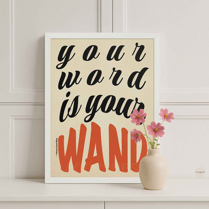 Beige background poster with “Your Word Is Your Wand” quote in black and red lettering, displayed in a sleek white frame against a soft, calming backdrop.