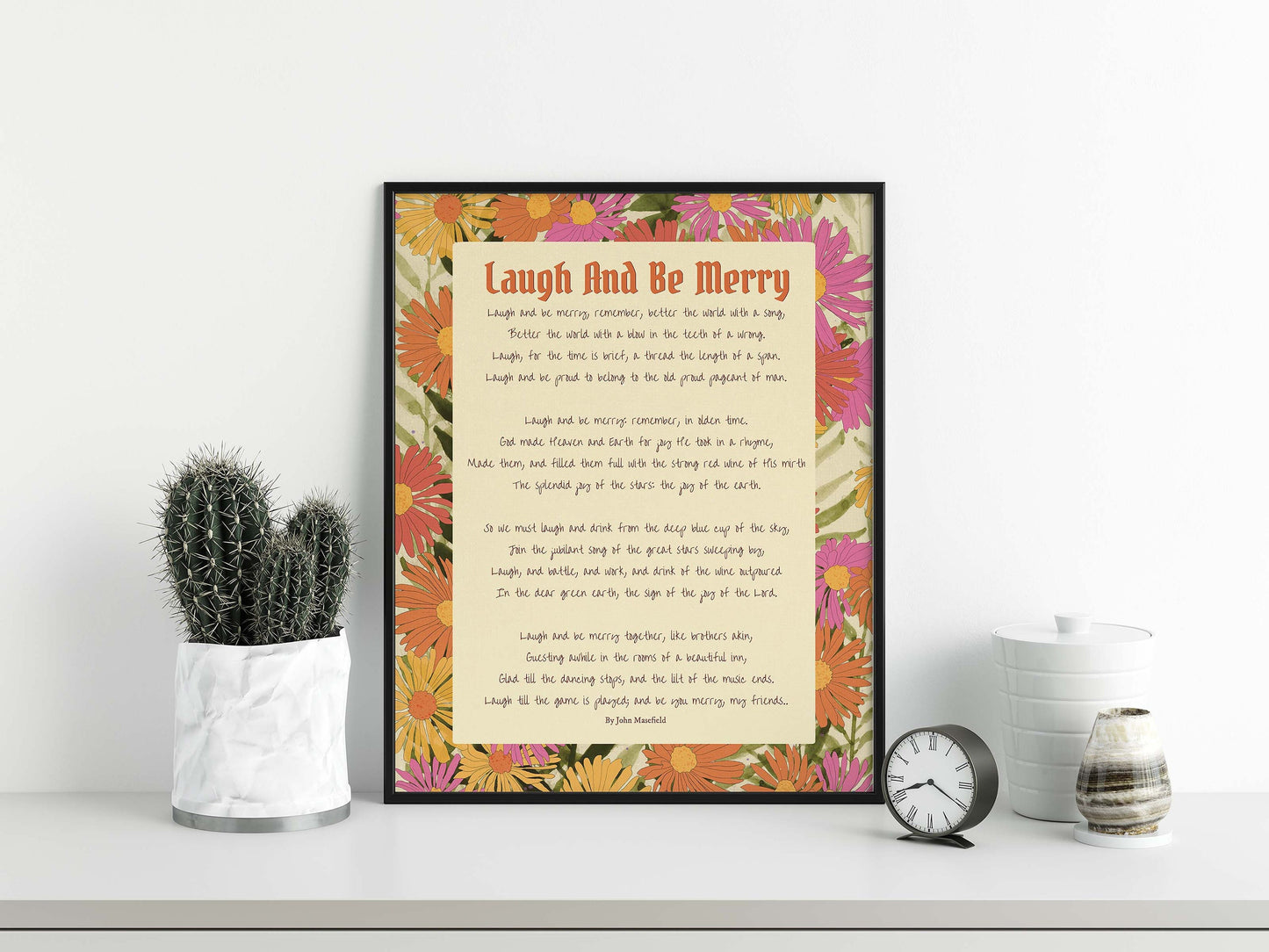 Laugh & Be Merry poem by John Masefield print with floral design in pink, orange, green, beige & yellow in black frame mockup