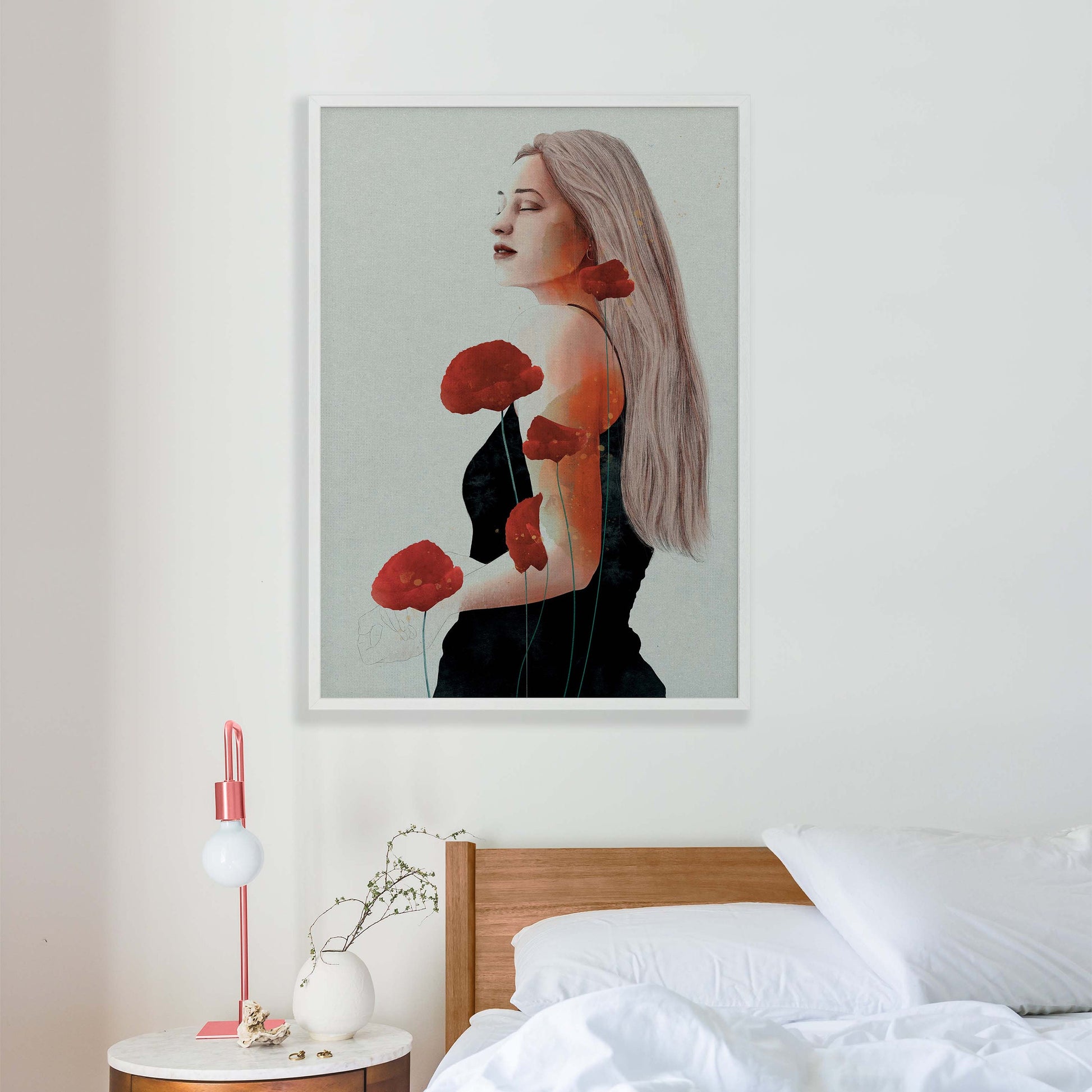 Woman in black dress with red poppy art print in white frame in bedroom